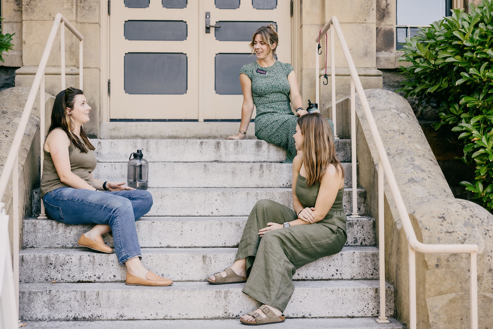 three women sitting on steps discussing sustainability issues