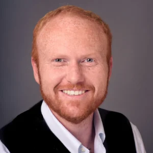 man with red hair and beard wearing white shirt