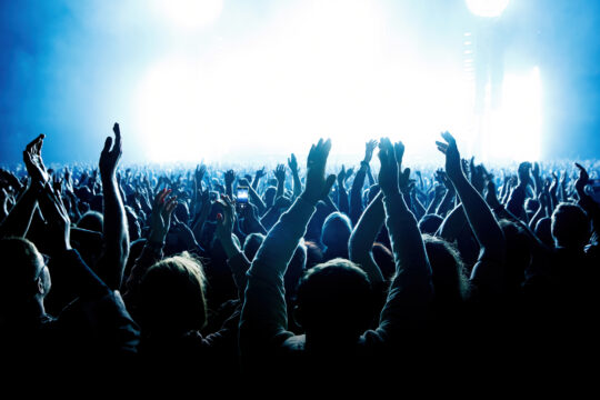 A crowd of people with raised arms during a music concert